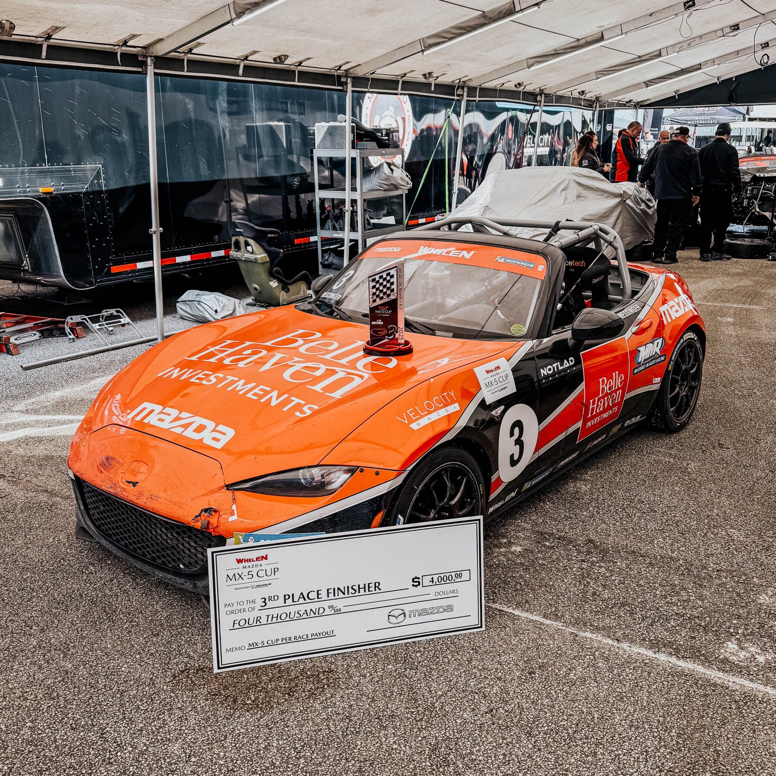 Ren's number 3 MX-5 Cup car in Belle Haven Investments livery with his Daytona podium trophy